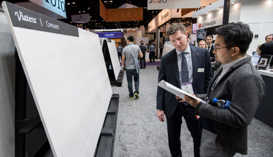 LG하우시스는 10일 미국 조지아주 인조대리석 공장에 5000만 달러를 투자해 엔지니어드 스톤 3호 생산라인을 증설한다고 밝혔다. 올해 상반기 미국 올랜도에서 열린 주방·욕실 전시회인 'KBIS 2018'에서  LG하우시스 직원이 미국 현지 소비자에게 엔지니어드 스톤 제품에 대해 설명하고 있다. <LG하우시스 제공>